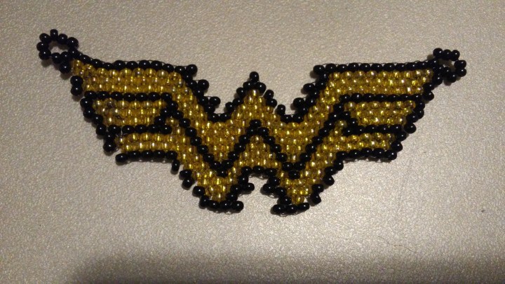 gold and black Wonderwoman symbol pendant made from seed beads